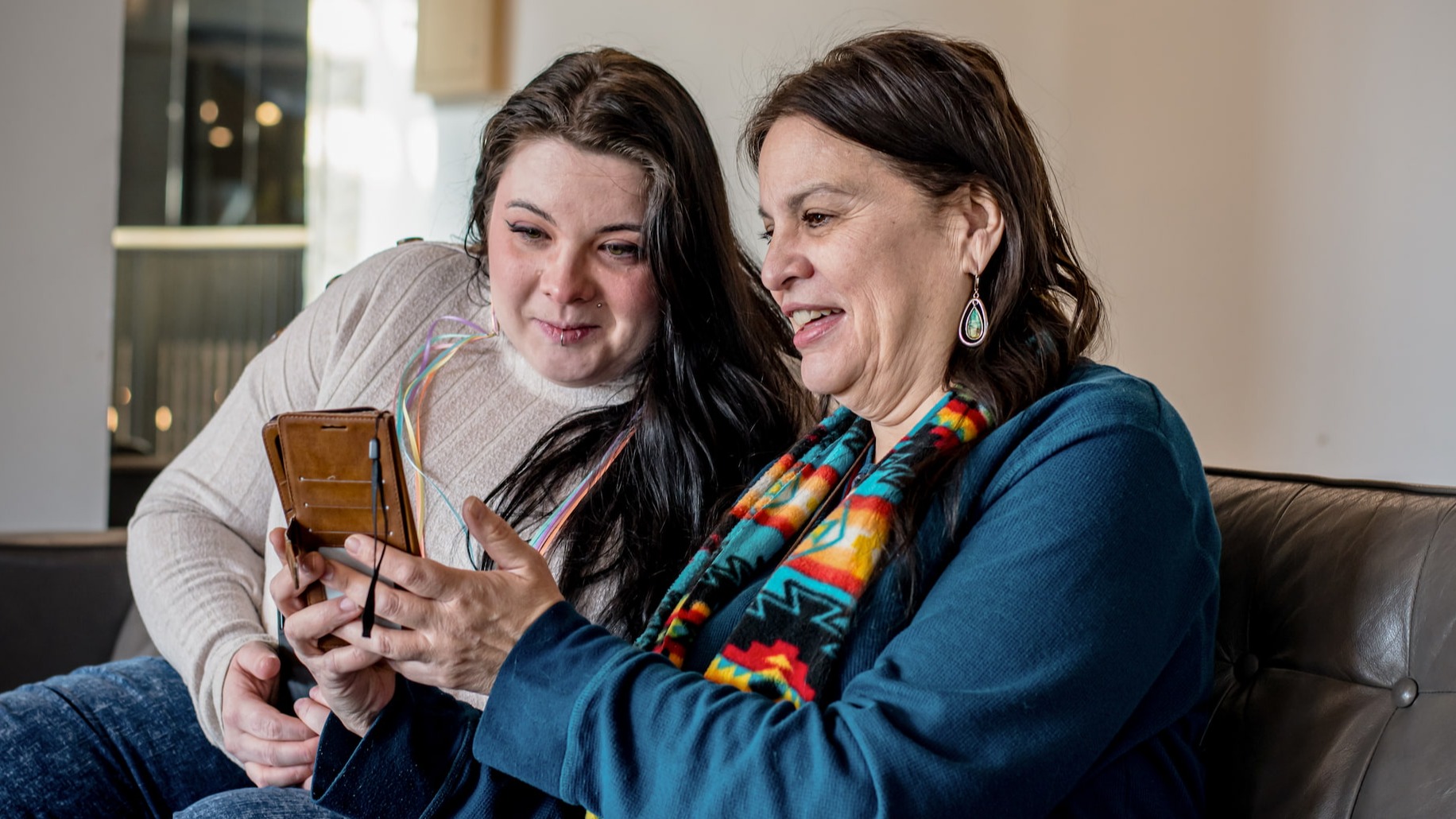 A young woman helps her mother with her smartphone