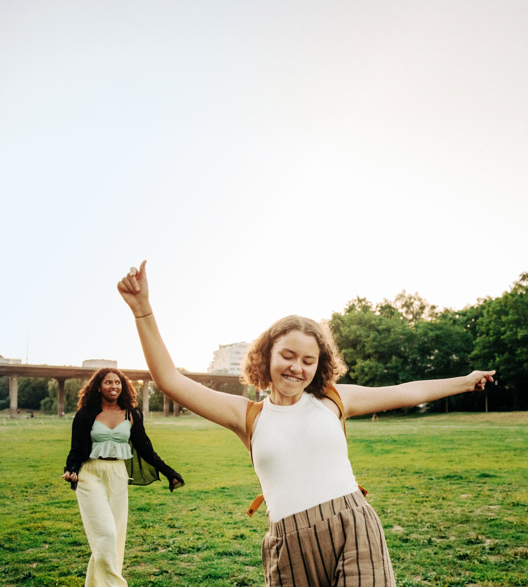 Teenagers dancing and taking pictures in a field