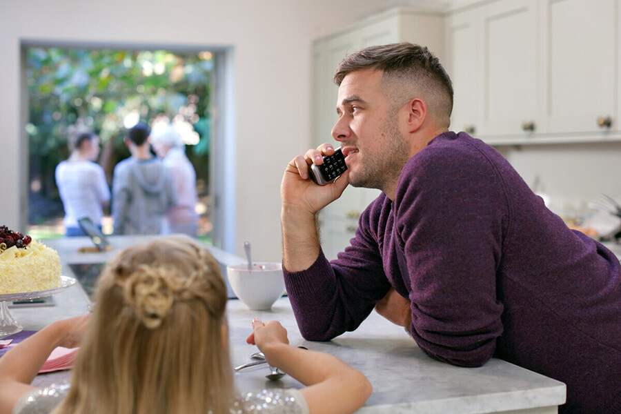 Man leaning on a kitchen worktop speaking on a phone