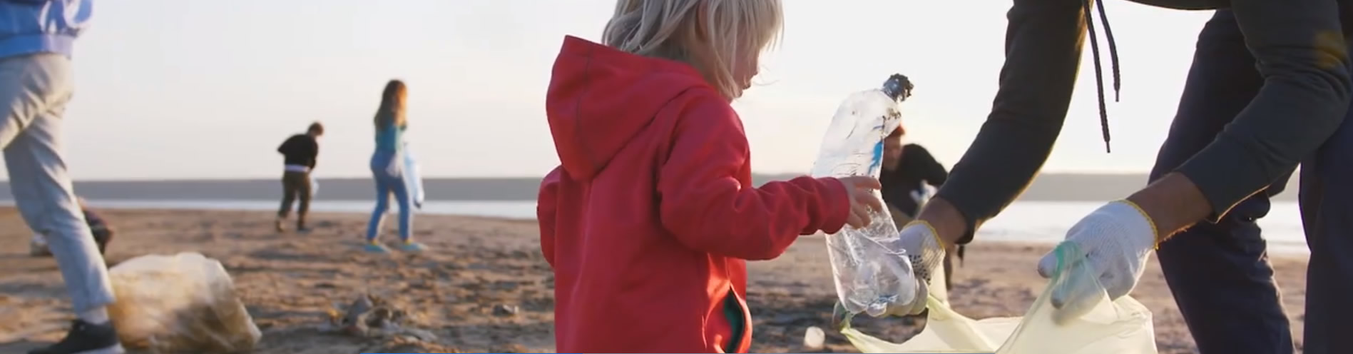 Toddler clearing up rubbish on beach