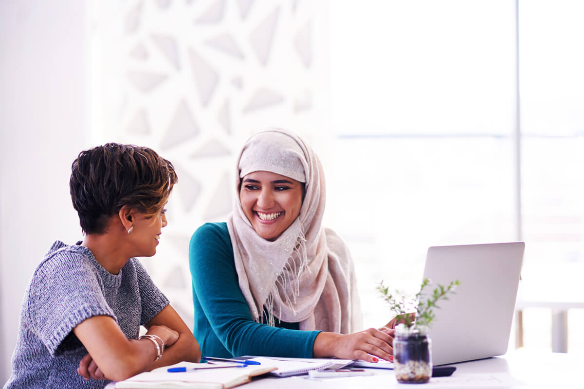 Two women working on a laptop