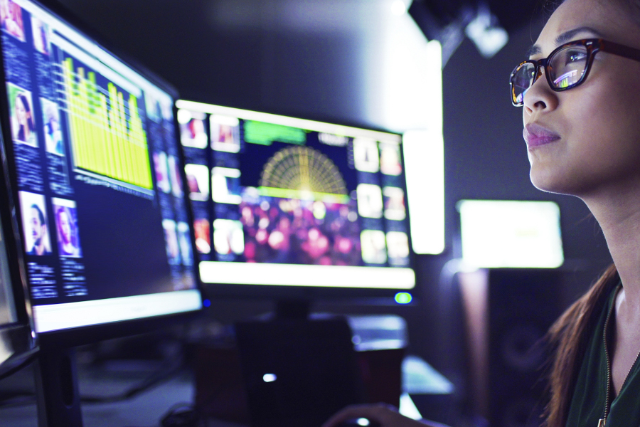 Young woman looking at computer monitors