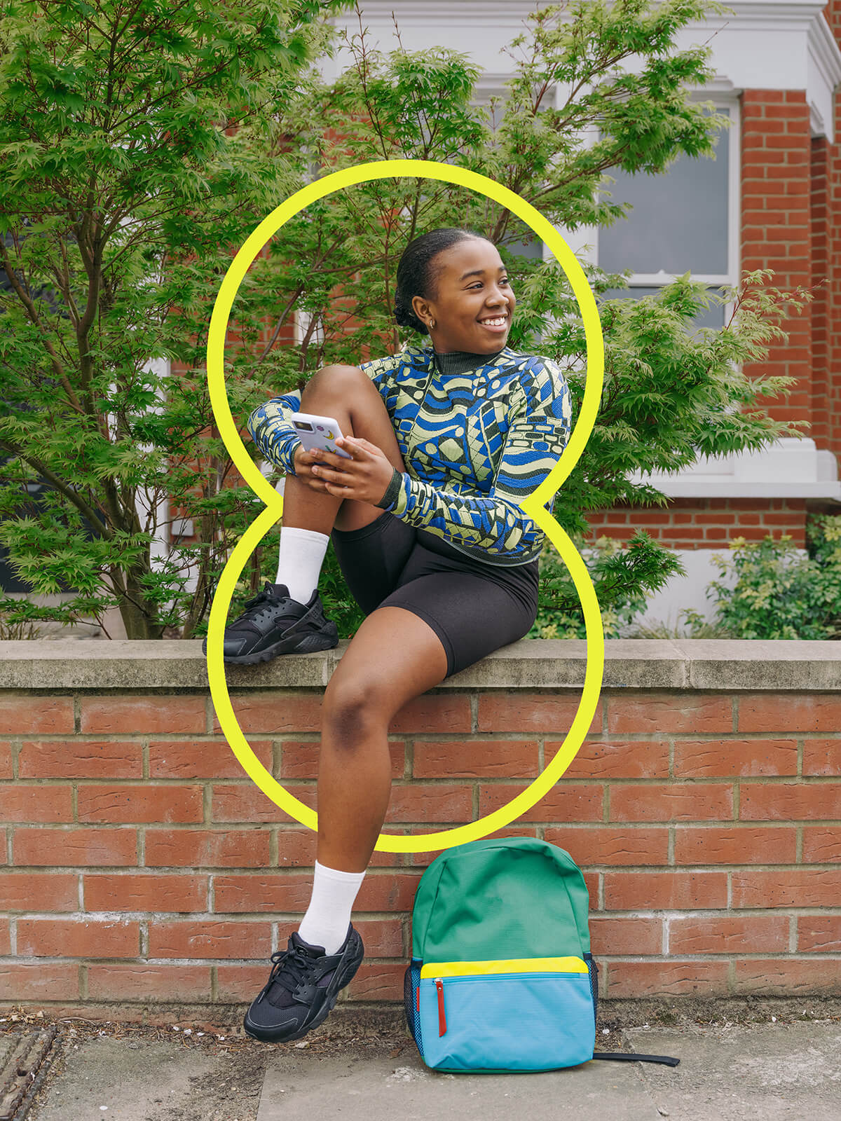 Girl wearing cycling gear sitting on a wall